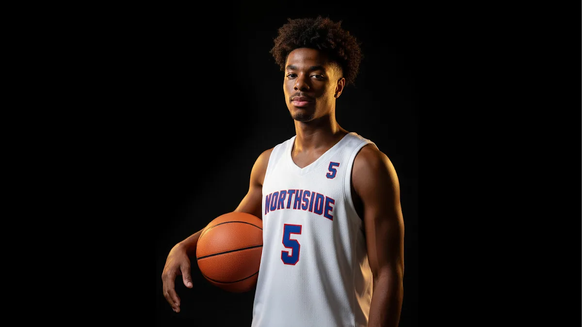A young basketball player photographed against a black backdrop with a single hard directional light.